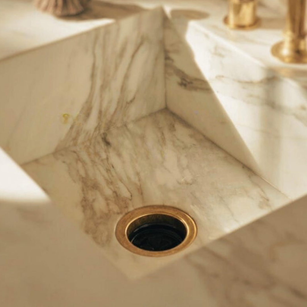 Unlacquered brass disposal flange installed in kitchen sink