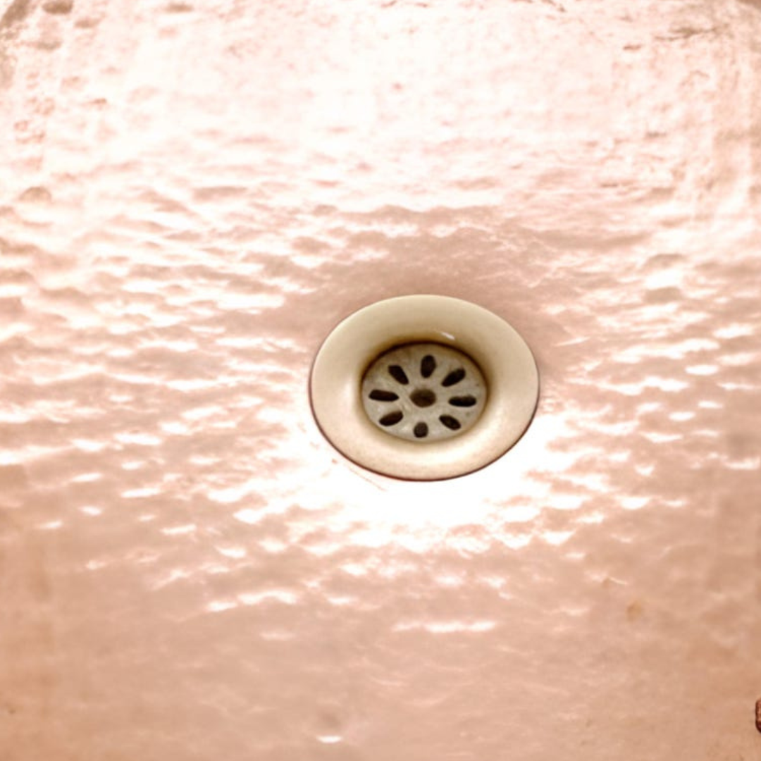 Copper bathtub interior drain detail — hammered floor close-up