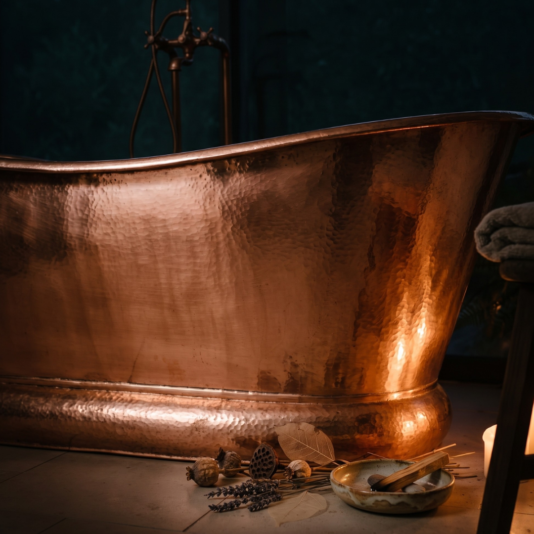Interior of hammered copper bathtub — top-down view of dimpled surface and drain