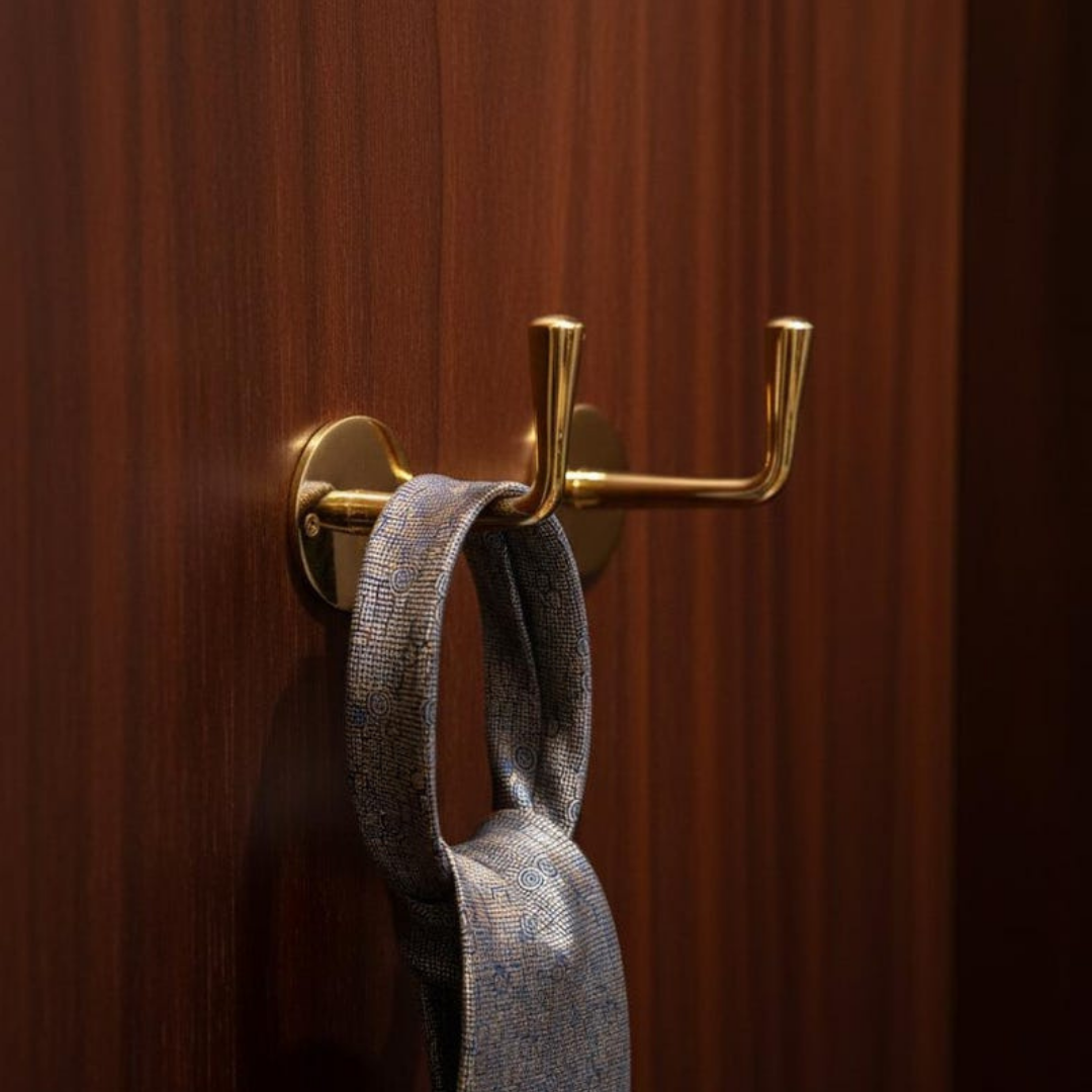 Detail of a solid brass hook with unlacquered patina