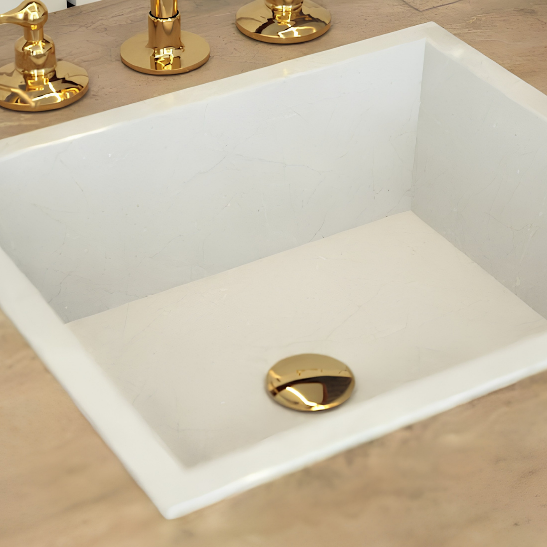 Unlacquered brass sink stopper installed in a minimalist bathroom sink