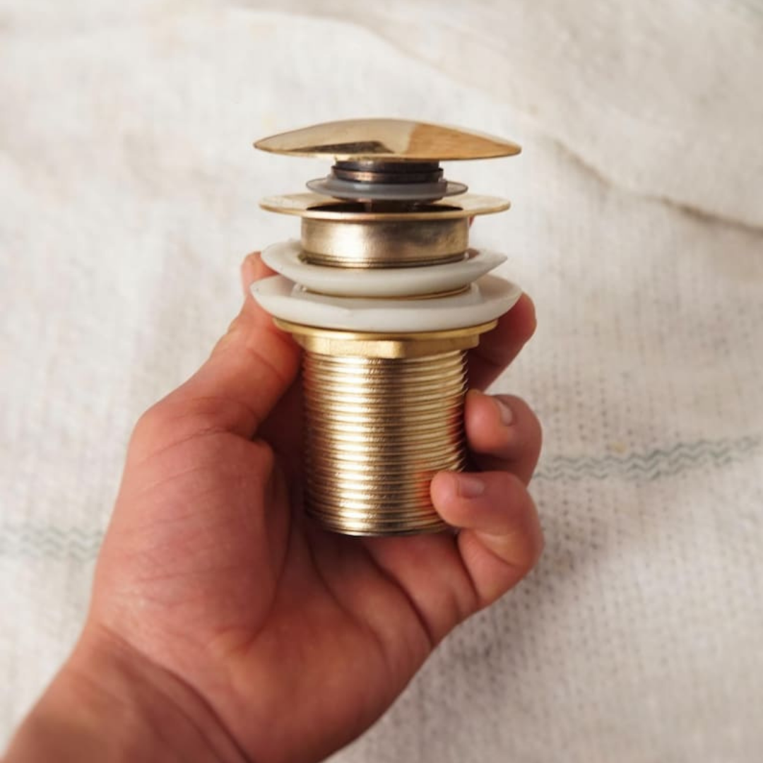 Close up of the unlacquered brass finish on a sink drain